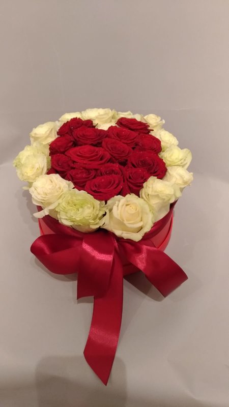 Apaļa dāvanu kaste ar baltām un sarkanām rozēm sirds formā