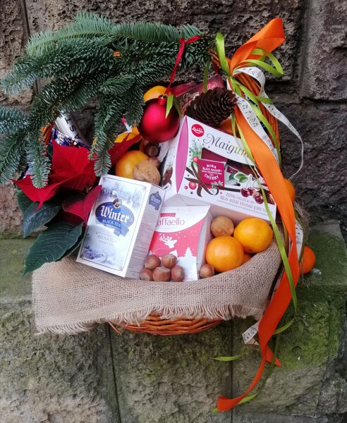 Ziemassvētku saldumu grozs ar Ziemassvētku zvaigzni (Puansetiju) un svētku dekoriem